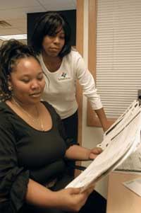 LEARNING CURVE: On-site programs help stabilize residents' lives and rental communities. Here Gillette Williams, resident services director for Park Haven, works with resident Debra Myles.
