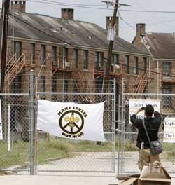 A man photographs the shuttered St. Bernard low-income housing project in July 2006, almost one year after Hurricane Katrina flooded this area of the city. New Orleans public housing residents recently filed a civil rights lawsuit against the city's housing authority and HUD.