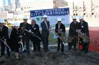 Village Green chairman and CEO Jonathan Holtzman (third from right) joins a development team including representatives from US Bank, the Minneapolis City Council, and Minneapolis mayor R.T. Ryback (fourth from right) for the groundbreaking of the $33 million Mill District City apartments.