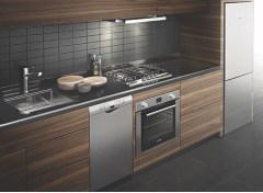 Breaking up the stove and dishwasher with an undercounter oven and separate cooktop allows the front edge of the counter to run continuously across the length of a small kitchen, reducing visual chaos.