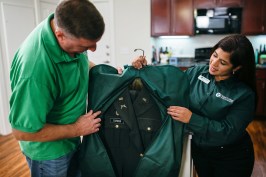 Navy veteran and Valet Giving Hero recipient Andrew Durbin receives his laundry delivery from Valet Living associate Valerie Hernandez.