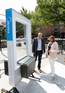 Kurt Jovais, president of Midea America Corp., and Doreen Harris, president and CEO of the New York State Energy Research and Development Authority, inspect a Midea product display at Woodside Houses, a public housing community in New York City. Midea America Corp. is developing new new heat pump technology to decarbonize New York City Housing Authority buildings.
