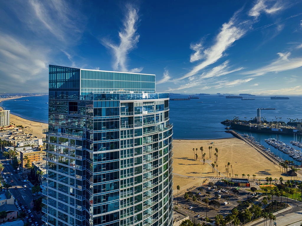 Shoreline Gateway in Long Beach, California, takes cues from the ocean with sail iconography along the south elevation and the sweeping glass curvature of the building offering ocean views from almost every unit.