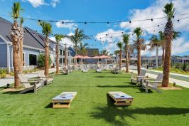 Residents of Thompson Thrift Residential’s The Sophia in Venice, Florida, can enjoy poolside cornhole and lawn games on artificial turf.