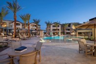 A pool and palm trees in front of a building