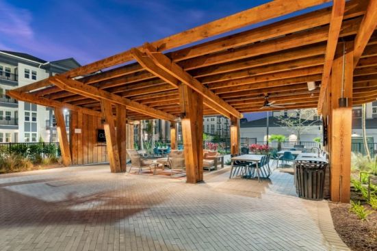 Overlooking the pool, the resident pavilion at Azola South Tampa offers a shady place to lounge, cook, dine, and gather.