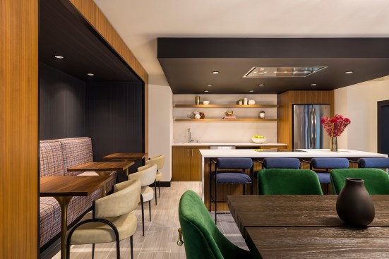 Chef's kitchen in new apartment building with stylish modern kitchen and tables and chairs