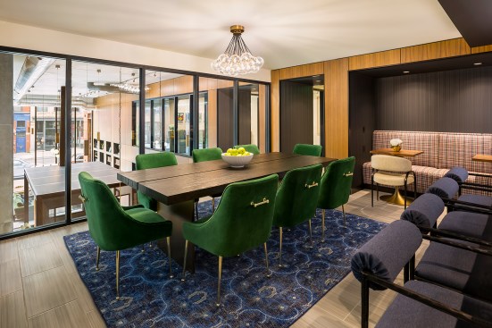 Dining area of chef's kitchen with view down to two story lobby of apartment building