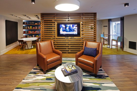 The older-millennial crowd wants a choice of indoor gathering spaces for unwinding or studying, and since the development is near a major university, a library space with bookshelves and reading areas seemed de rigueur.