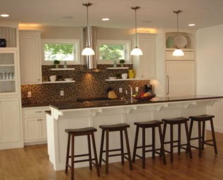 Most beach houses keep things on the lighter side. Cottage Home stayed true to form with the crisp millwork in this waterfront home on the shores of Lake Michigan, but the team also made a bold move with a warm, dark backsplash wall of Oceanside Glass Geologie Denali tile that picks up the rich tones of the bar stools. “We actually got those great stools from Target,” says interior designer Vicki Zylstra. “We spent a crazy amount of money on the tile, but we balanced it with these inexpensive but impressive pieces. The bar stools and the tile make for a great combination – both visually and financially. Once you take the price tags off, it’s all about the look.” 
www.cottagehome.com