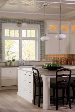 There’s a reason farmhouse kitchens are topping the popularity charts these days. They’re warm and inviting, but not over the top. Interior designer Julie Holmes struck just the right balance in this Michigan home designed by Visbeen Associates with a pretty tile combo that feels fresh and clean. Mossy-toned mosaic tiles outlined with a light grout give the appearance of folksy gingham on most of the wall, but they stop short of meeting up with the countertop. It’s at this juncture that a border of creamy subway tiles turned vertical lends an air of sophistication, while also providing a more seamless, cleanable finish in areas that are exposed to dirt and water. 
www.visbeen.biz