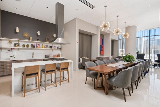 The communal kitchen at The Sinclair can seat 24 for gatherings, with china and cutlery provided, which makes entertaining outside one's apartment easy. Residents can even shop at the grocery store on-site, reaching it from indoors.