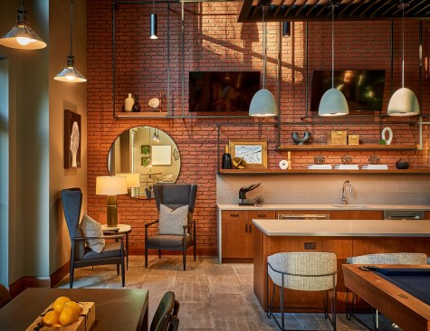 The Raven Residences, designed by Mary Cook Associates, in Chicago features common spaces with matte black metals and brickwork that references the exterior architecture.