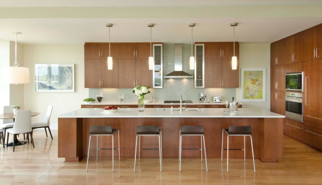 Sleek kitchens feature an off-white and gray backdrop accented with cherry cabinets and French limestone counters.