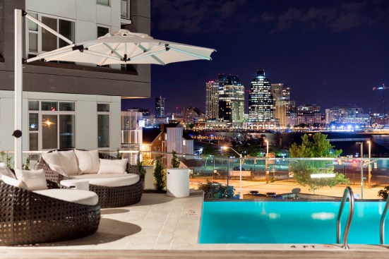 An infinity-edge pool lends the rental building a boutique-hotel style, and a nearby stairway leads down to the waterfront and a running path, in keeping with the building's health-minded orientation.