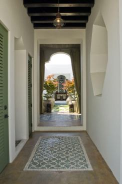 This modest, Spanish-style townhouse is oriented along two axes that culminate in a center courtyard. The home’s entry hall is intentionally dark in contract to the sun-drenched oasis in the middle of the plan.  Decorative floor tiles and Andalusian archways direct the eye down the hall and back outside. 
Architect: Khoury & Vogt Architects, Alys Beach, Fla. 
Builder: Wave Construction, Rosemary Beach, Fla.