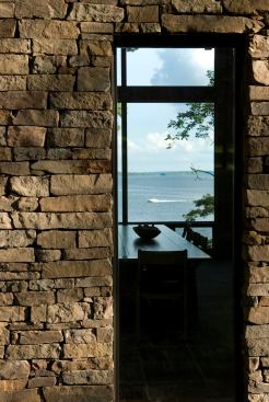 Located in a traditional subdivision, this waterfront home opens wide out back but is a bit more modest with its front elevation. Tall, skinny Pella windows surrounded by stone cladding maintain a degree of privacy from the street while offering peephole views through the house to the lake. 
Architect: archimania, Memphis 
Builder: McNairy County Construction, Selmer, Tenn.