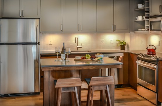 Kitchens at the development offer movable islands, hickory floors, and vertically laid subway tile.