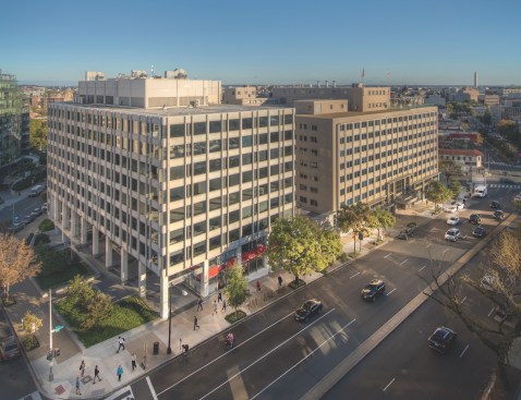 The Geneva will merge two buildings on the site. One is a long, narrow building. The second building wraps its rentable space around a parking garage.