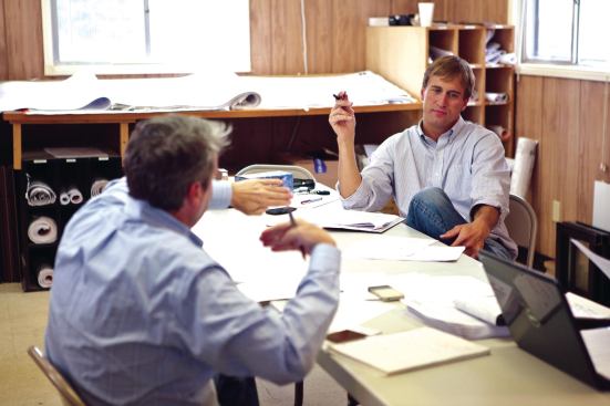 Branch Properties development manager Ray Crocker (facing camera) runs through the agenda with Summit’s project manager, Zachary Graham, during the weekly owners meeting. 