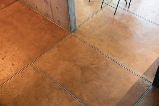 The 3-in.-thick concrete floor is placed over radiant heating coils. After stamping textures in the fresh concrete, workers troweled the floor, removing half the impressions.

