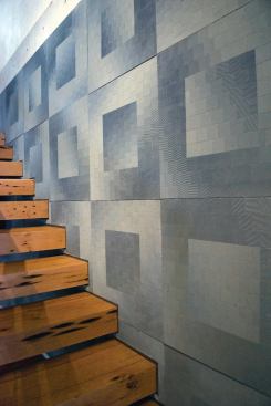 Patterned precast panels that change with the angle of view and lighting conditions were attached to a shear-wall. The only support for the steps is their anchorage to the concrete wall.

