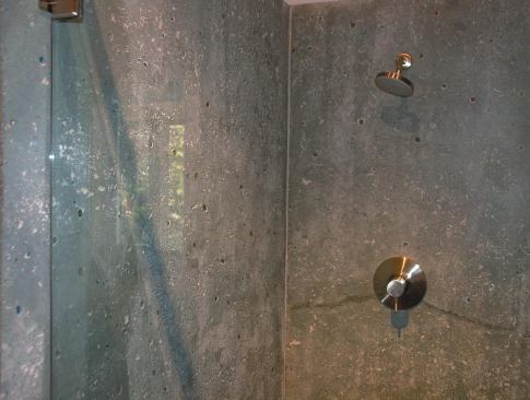 This shower was made with precast, colored concrete with no attempt to control bug holes. Other showers in the home were made with cast-in-place overlay concrete. 

