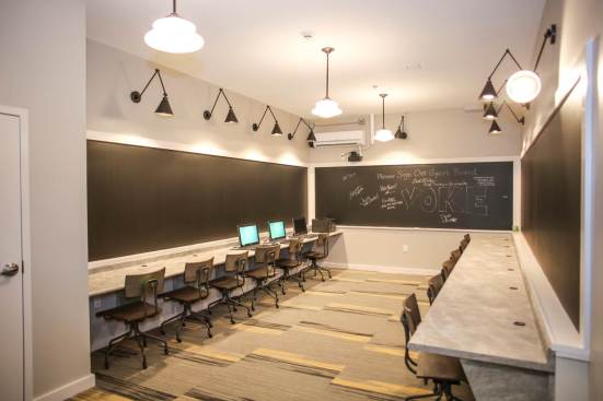 The computer lab at Voke Lofts pays homage to the building's earlier incarnation as a vocational school—right down to the schoolhouse chairs.